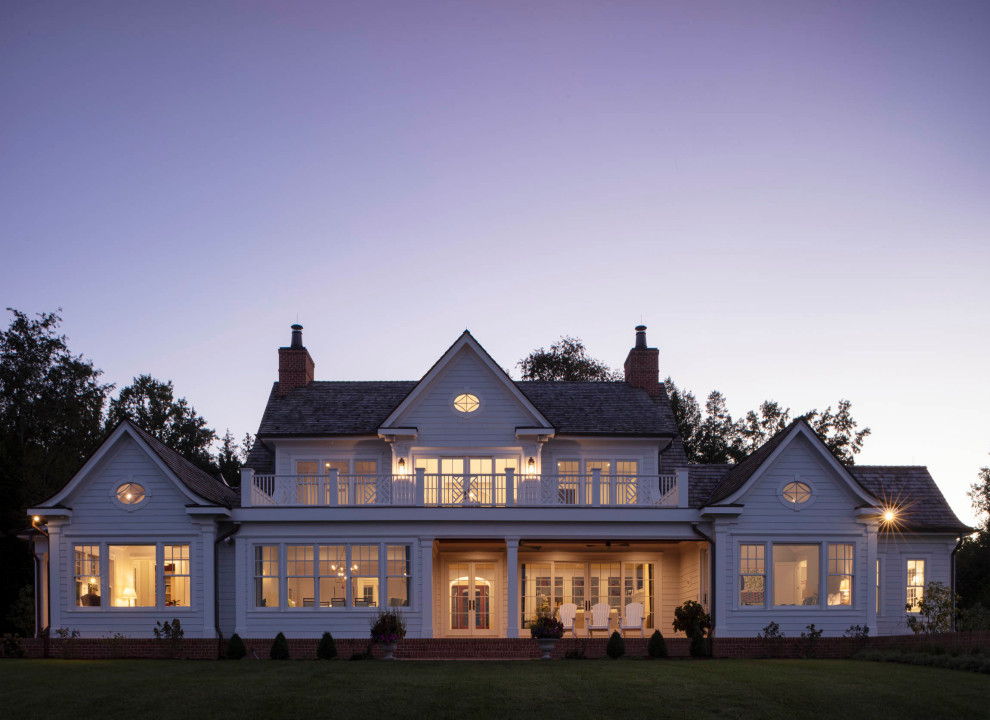 Пример оригинального дизайна: большой, двухэтажный, белый частный загородный дом в классическом стиле с крышей из смешанных материалов и коричневой крышей