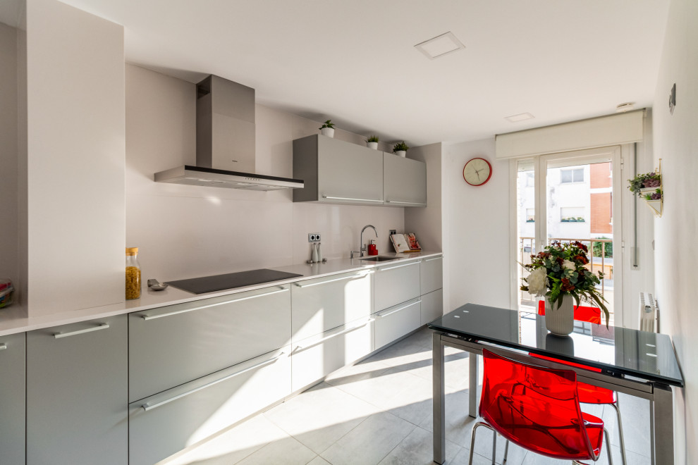 Photo of a large contemporary separate kitchen with an undermount sink, flat-panel cabinets, grey cabinets, soapstone benchtops, white splashback, stainless steel appliances, ceramic floors, no island, grey floor and white benchtop.