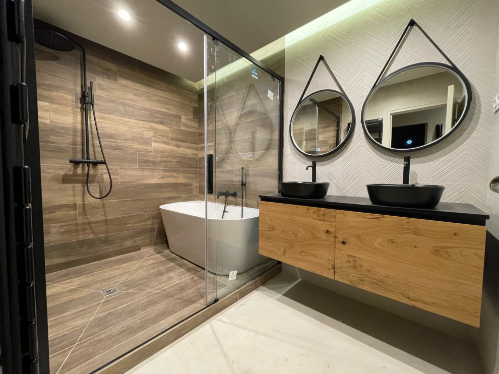 Mid-sized contemporary master wet room bathroom in Other with black cabinets, a freestanding tub, beige tile, wood-look tile, beige walls, wood-look tile, a drop-in sink, tile benchtops, a sliding shower screen, black benchtops, a double vanity, a floating vanity and recessed.