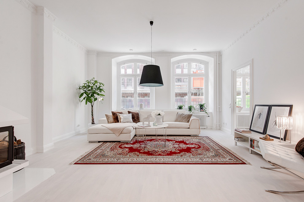 Photo of an expansive scandinavian formal open concept living room in Stockholm with white walls, painted wood floors, no fireplace and no tv.