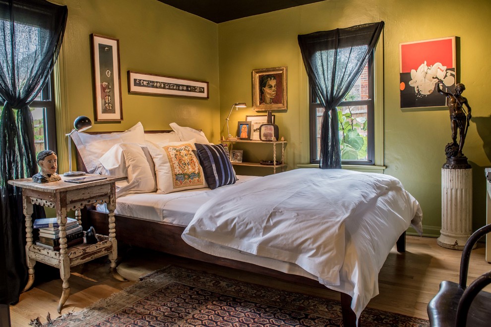 Inspiration for an eclectic bedroom in St Louis with green walls, medium hardwood floors and brown floor.