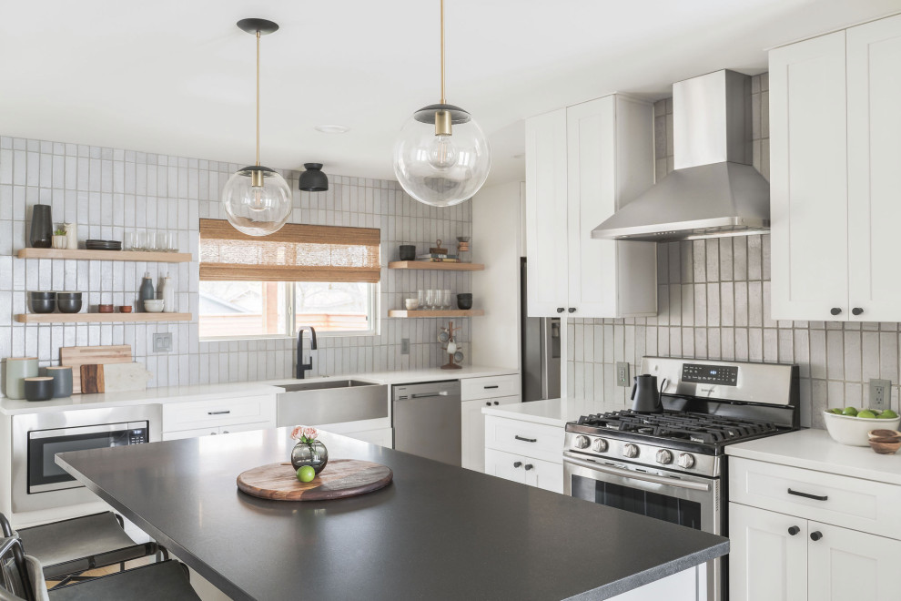 Mid-sized transitional l-shaped kitchen photo in Austin with shaker cabinets, white cabinets, quartz countertops, gray backsplash, brick backsplash, stainless steel appliances, an island and white countertops