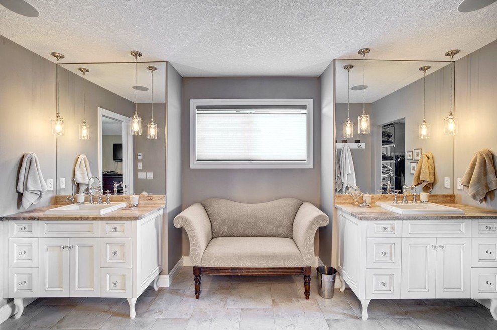 Inspiration for a traditional master bathroom in Calgary with raised-panel cabinets, white cabinets, beige walls, ceramic floors and soapstone benchtops.