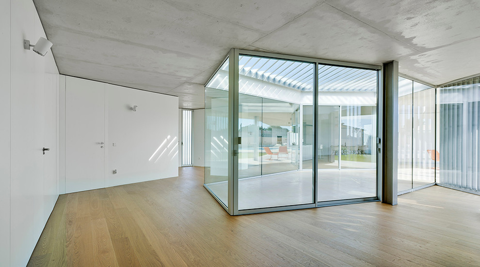 Imagen de recibidores y pasillos actuales de tamaño medio con paredes blancas y suelo de madera en tonos medios