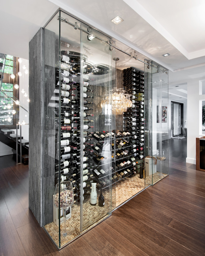 This is an example of a large contemporary wine cellar in Ottawa with dark hardwood floors, display racks and brown floor.
