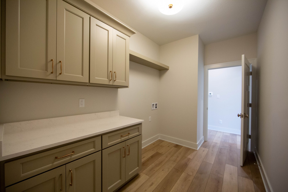 Mid-sized elegant single-wall laminate floor and brown floor dedicated laundry room photo in Indianapolis with recessed-panel cabinets, brown cabinets, quartz countertops, beige walls, a side-by-side washer/dryer and white countertops