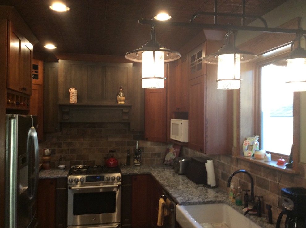 Inspiration for a rustic u-shaped porcelain tile eat-in kitchen remodel in Chicago with a farmhouse sink, shaker cabinets, porcelain backsplash, stainless steel appliances, a peninsula, dark wood cabinets, quartz countertops and brown backsplash