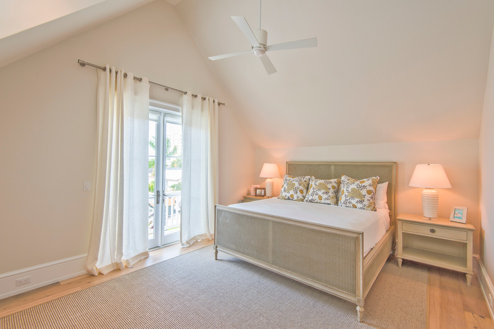Design ideas for a large beach style guest bedroom in Tampa with beige walls and light hardwood floors.