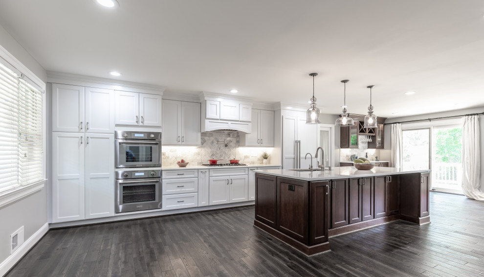 Design ideas for a large contemporary kitchen in DC Metro with white cabinets, granite benchtops, multi-coloured splashback, stainless steel appliances, dark hardwood floors, a peninsula, brown floor and white benchtop.
