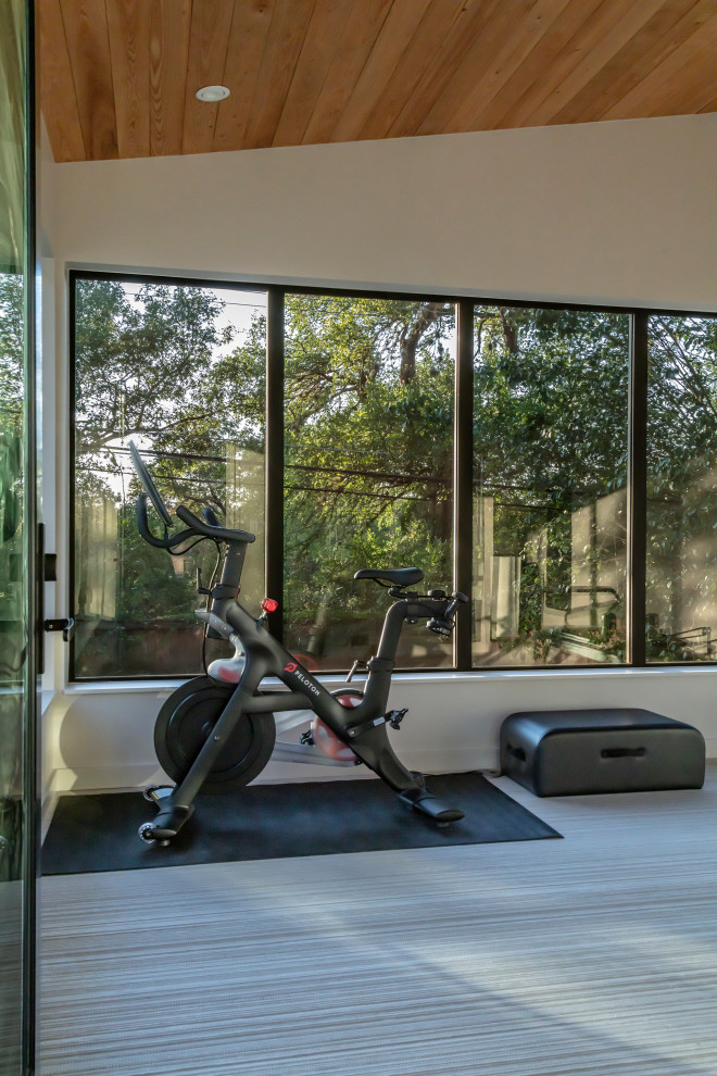 Inspiration for a small modern multipurpose gym in Austin with white walls, grey floor and wood.