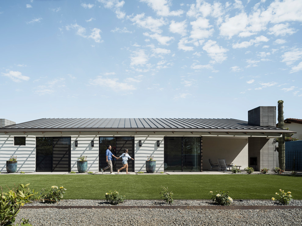 Diseño de fachada de casa blanca y negra moderna de una planta con revestimiento de estuco, tejado de un solo tendido y tejado de metal