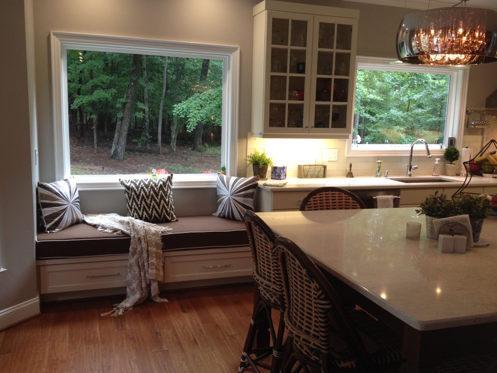 Large transitional medium tone wood floor eat-in kitchen photo in Raleigh with an undermount sink, shaker cabinets, white cabinets, quartz countertops, gray backsplash, ceramic backsplash, stainless steel appliances and an island