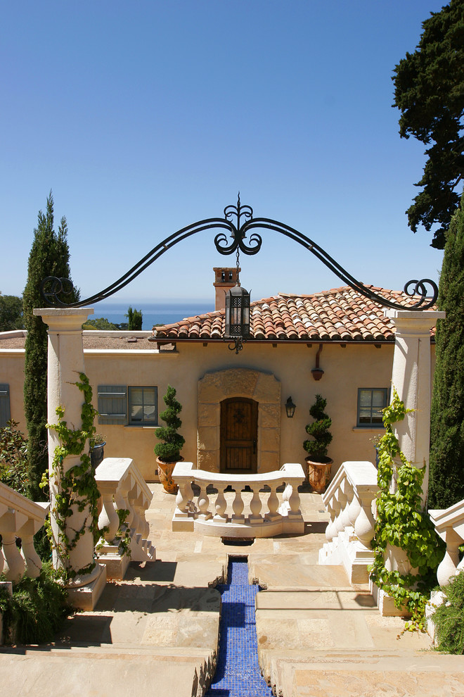 This is an example of a mediterranean entryway in Santa Barbara with a single front door and a dark wood front door.
