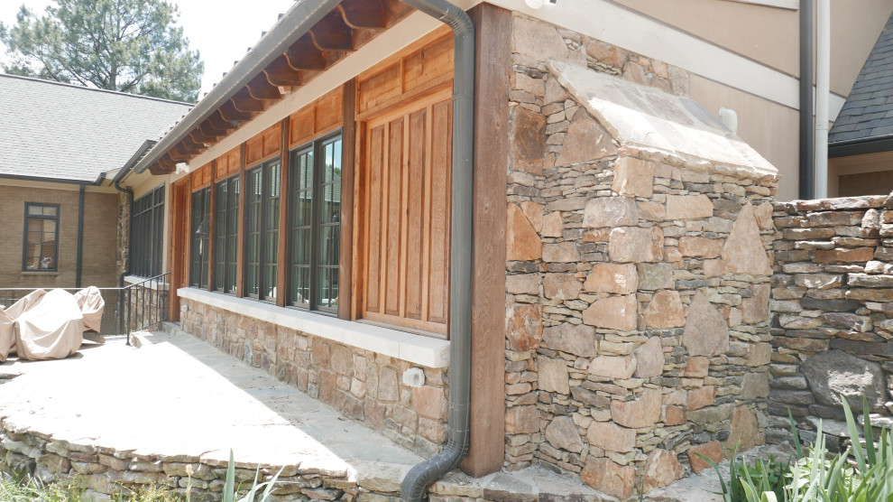 Exemple d'une véranda sud-ouest américain de taille moyenne avec un sol en calcaire, une cheminée standard, un manteau de cheminée en pierre de parement, un plafond standard et un sol multicolore.