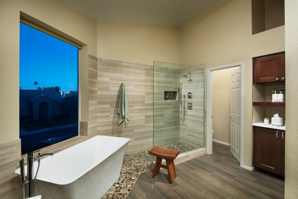 Inspiration for a transitional master beige tile and porcelain tile pebble tile floor freestanding bathtub remodel in Phoenix with shaker cabinets, dark wood cabinets, beige walls and quartz countertops