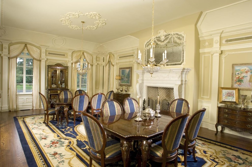 Photo of an expansive traditional open plan dining in New York with beige walls, dark hardwood floors, a standard fireplace and a plaster fireplace surround.