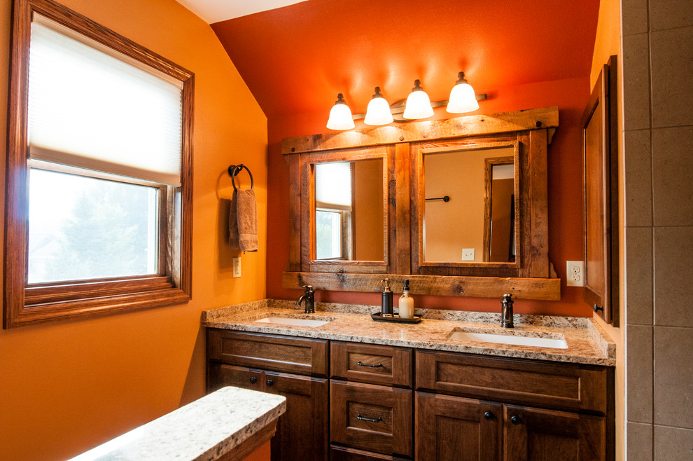 Inspiration for a small country master bathroom in Milwaukee with an undermount sink, shaker cabinets, medium wood cabinets, granite benchtops, an alcove shower, a one-piece toilet, beige tile, ceramic tile, orange walls and porcelain floors.