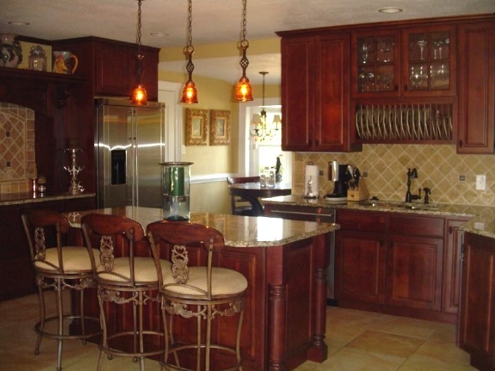 Kitchen pantry - mid-sized l-shaped ceramic tile kitchen pantry idea with a drop-in sink, dark wood cabinets, wood countertops, beige backsplash, ceramic backsplash, stainless steel appliances and an island
