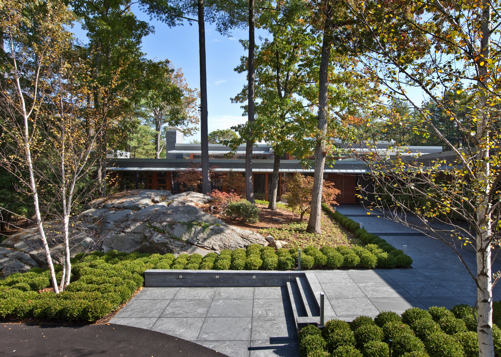 Example of a backyard stone patio design in Boston