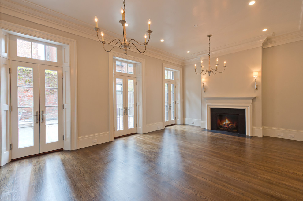 Traditional open concept living room in Boston with medium hardwood floors, a standard fireplace and a plaster fireplace surround.
