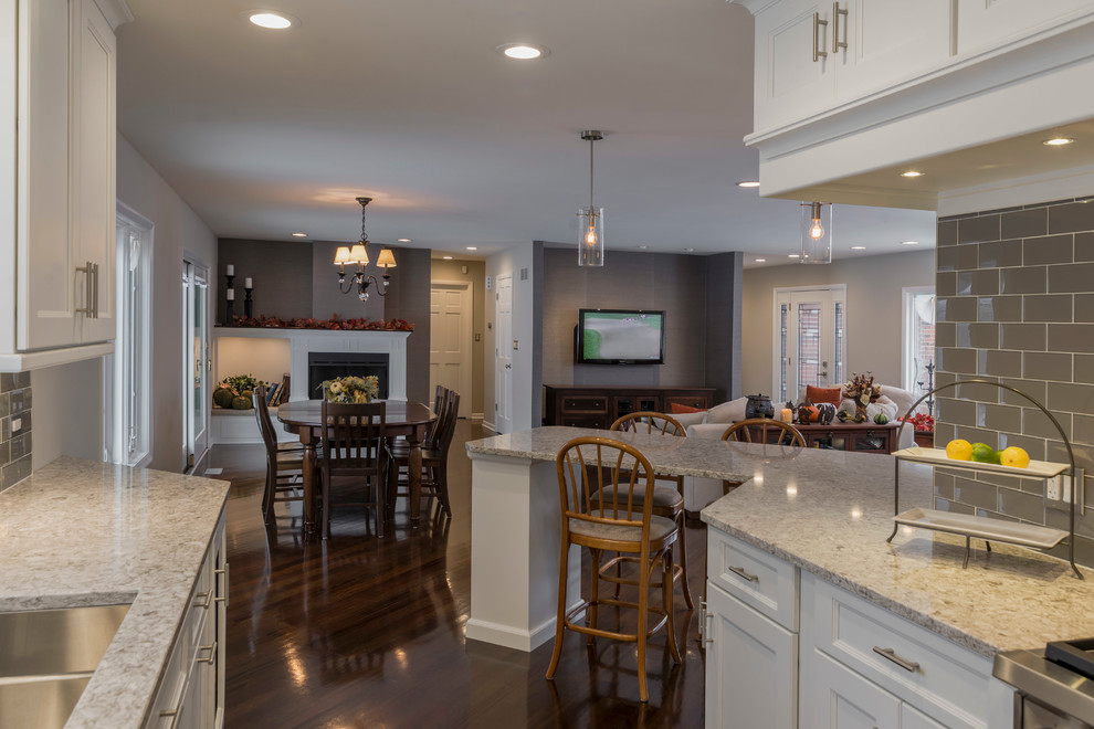 Mid-sized transitional galley medium tone wood floor eat-in kitchen photo in Chicago with an undermount sink, flat-panel cabinets, white cabinets, quartz countertops, beige backsplash, glass tile backsplash, paneled appliances and a peninsula