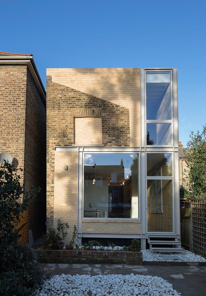 Contemporary two-storey brick beige exterior in London with a flat roof.