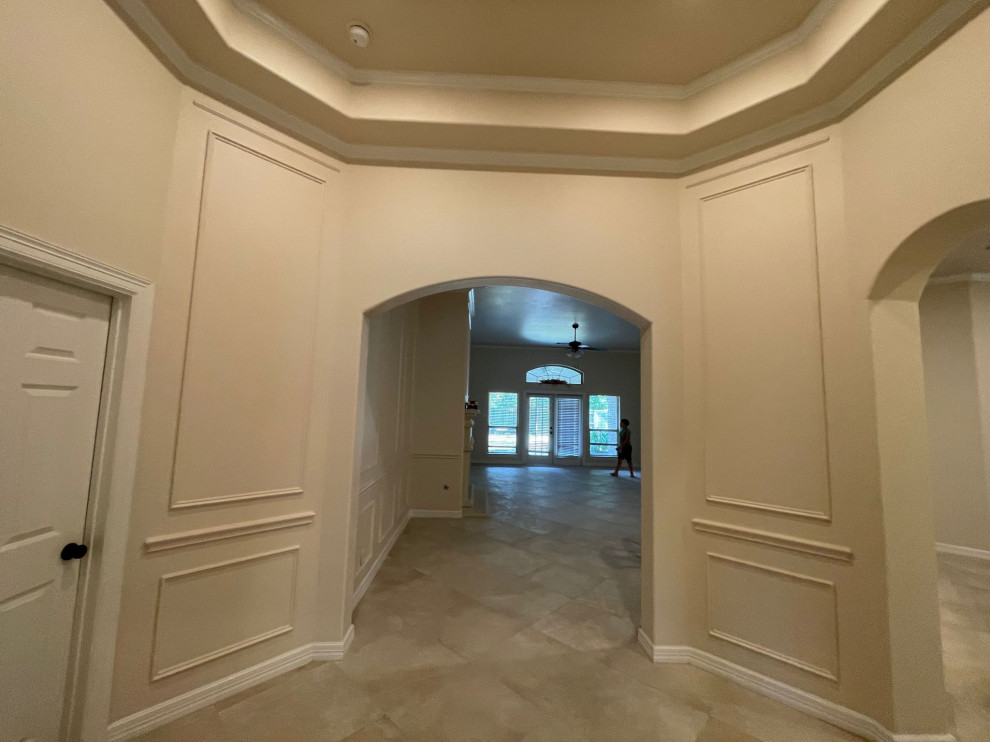 Esempio di un ingresso o corridoio mediterraneo di medie dimensioni con pareti beige, pavimento in gres porcellanato, pavimento beige, soffitto a cassettoni e pannellatura