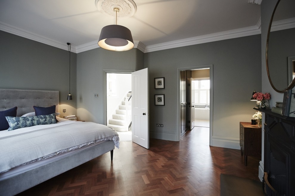 This is an example of a mid-sized transitional master bedroom in Sussex with grey walls, dark hardwood floors, no fireplace and brown floor.