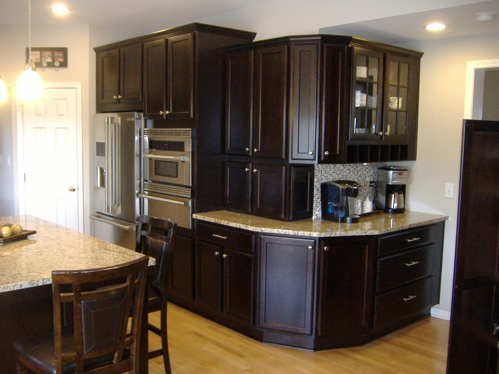 Example of a transitional u-shaped eat-in kitchen design in Indianapolis with an undermount sink, flat-panel cabinets, dark wood cabinets, granite countertops and stainless steel appliances