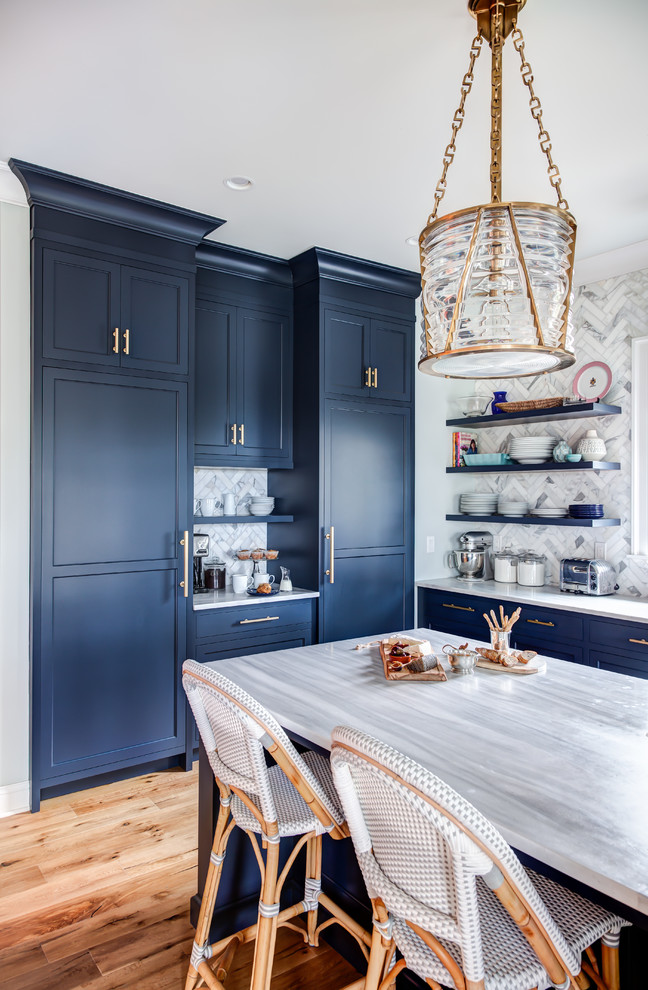 Large transitional l-shaped eat-in kitchen in New York with an undermount sink, recessed-panel cabinets, blue cabinets, granite benchtops, multi-coloured splashback, porcelain splashback, stainless steel appliances, medium hardwood floors, with island, brown floor and grey benchtop.