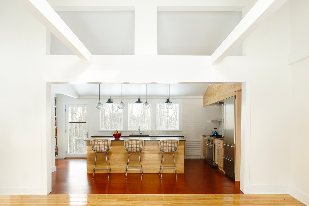 Photo of a country l-shaped kitchen in New York with shaker cabinets, medium wood cabinets, white splashback and with island.