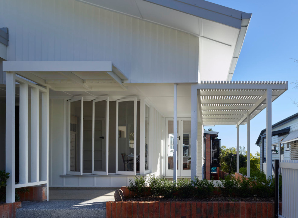 Imagen de fachada de casa blanca y blanca minimalista de tamaño medio de dos plantas con revestimiento de ladrillo, tejado a dos aguas, tejado de metal y tablilla
