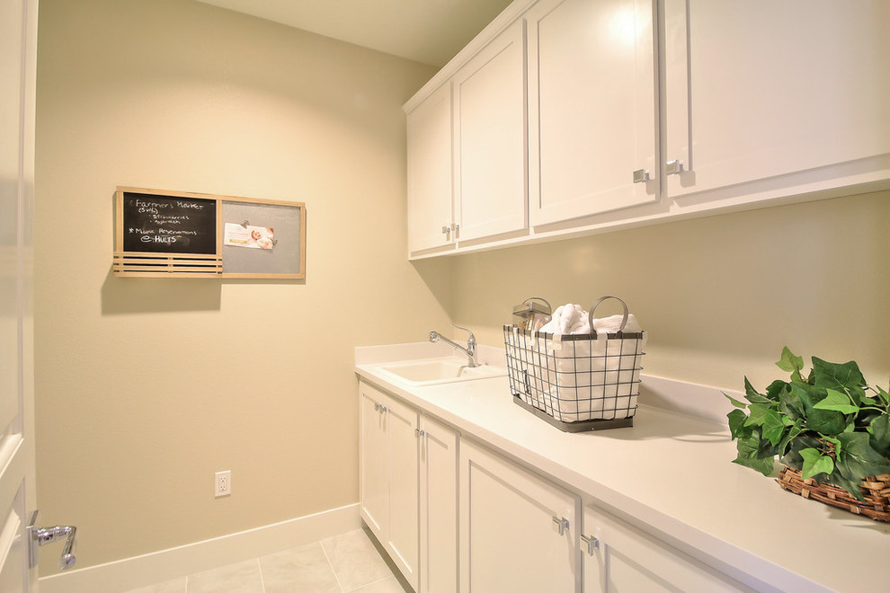 This is an example of an u-shaped dedicated laundry room in San Francisco with a drop-in sink, shaker cabinets and white cabinets.