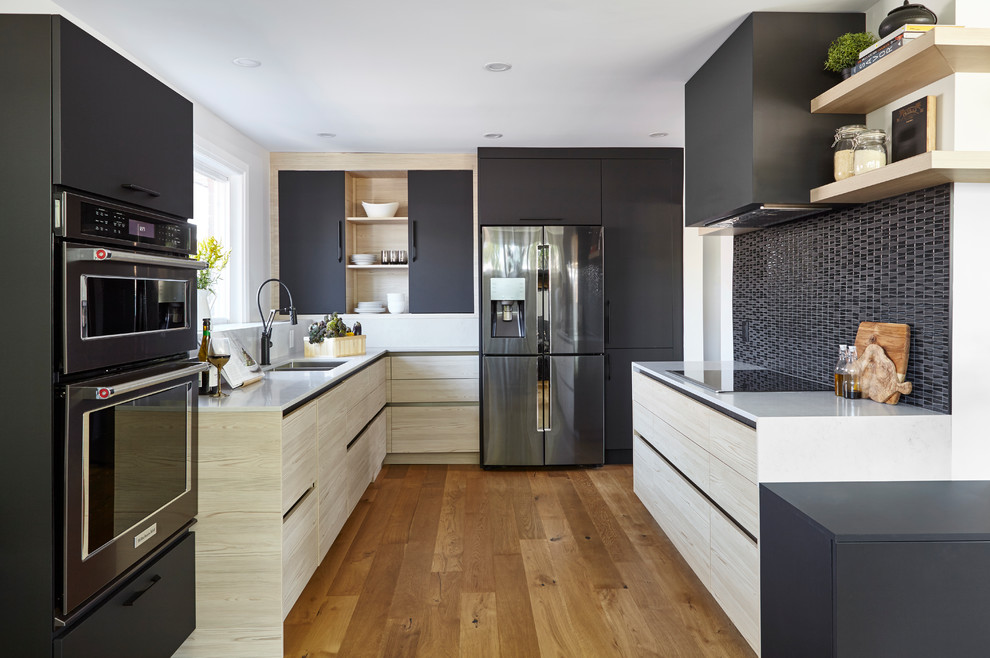 Inspiration for a mid-sized contemporary u-shaped open plan kitchen in Toronto with flat-panel cabinets, black splashback, medium hardwood floors, no island, brown floor, a double-bowl sink, light wood cabinets, quartzite benchtops, glass sheet splashback and stainless steel appliances.