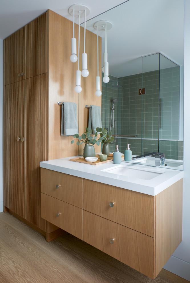 Photo of a contemporary bathroom in Toronto with flat-panel cabinets, medium wood cabinets, green tile, subway tile, white walls, light hardwood floors, an undermount sink, beige floor, white benchtops, a single vanity and a floating vanity.