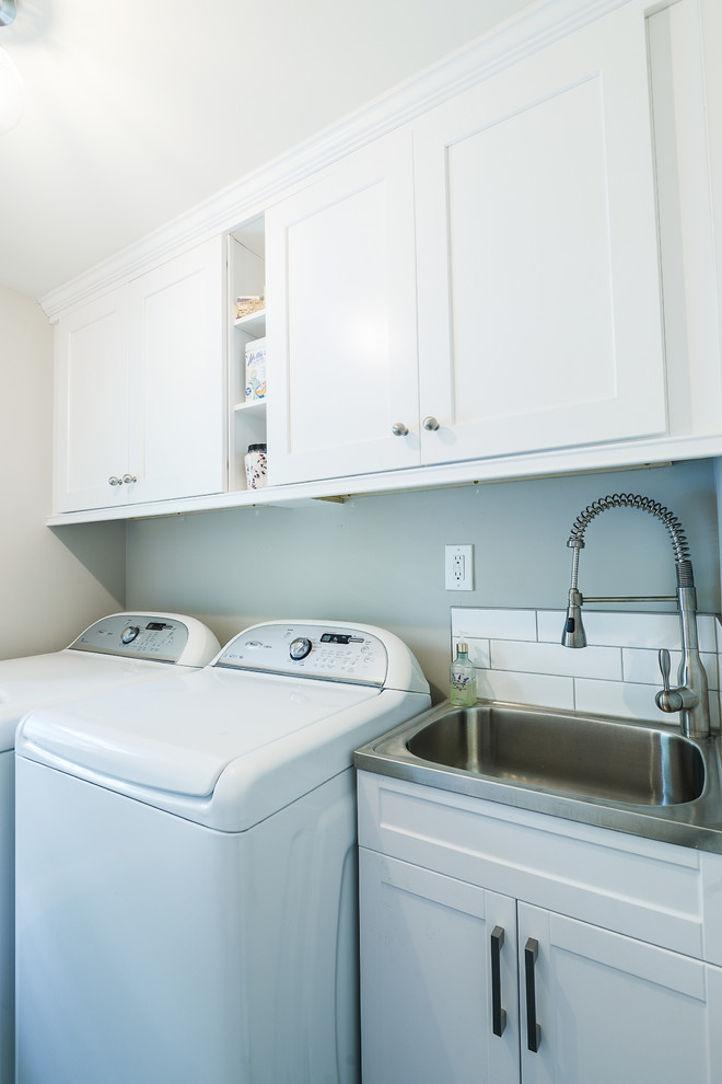 Photo of a transitional dedicated laundry room in Philadelphia with a drop-in sink, beaded inset cabinets, white cabinets, grey walls and a side-by-side washer and dryer.