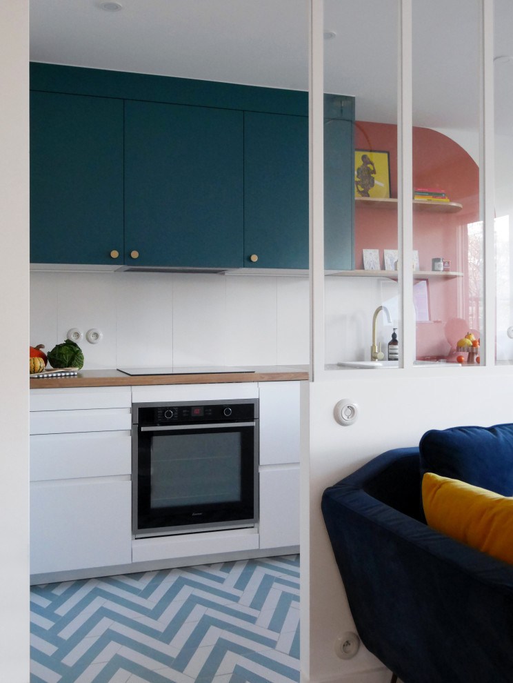 This is an example of a mid-sized modern l-shaped eat-in kitchen in Paris with a single-bowl sink, beaded inset cabinets, blue cabinets, laminate benchtops, white splashback, ceramic splashback, stainless steel appliances, ceramic floors, blue floor and beige benchtop.