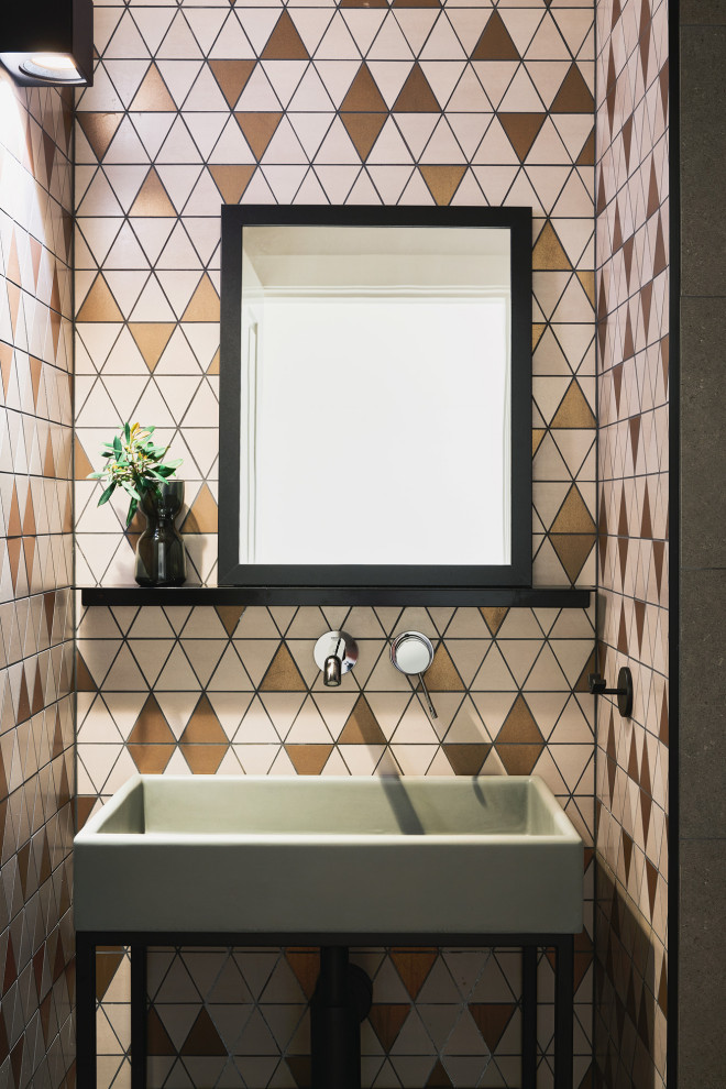 Photo of a small contemporary powder room in Melbourne with open cabinets, grey cabinets, multi-coloured tile, mosaic tile, multi-coloured walls, porcelain floors, a pedestal sink, concrete benchtops, grey floor, black benchtops and a freestanding vanity.