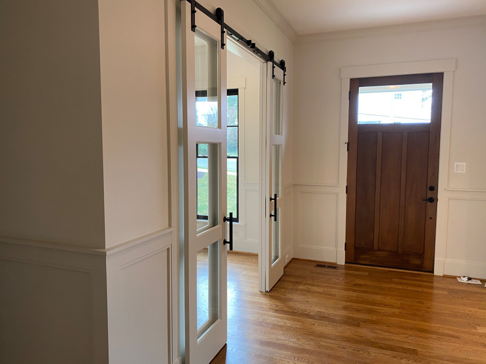 Foyer - large transitional medium tone wood floor and brown floor foyer idea in DC Metro with white walls and a medium wood front door
