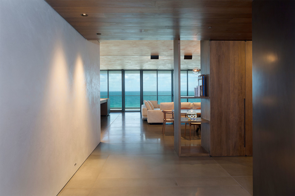 Design ideas for a mid-sized contemporary hallway in Miami with brown walls, porcelain floors and beige floor.