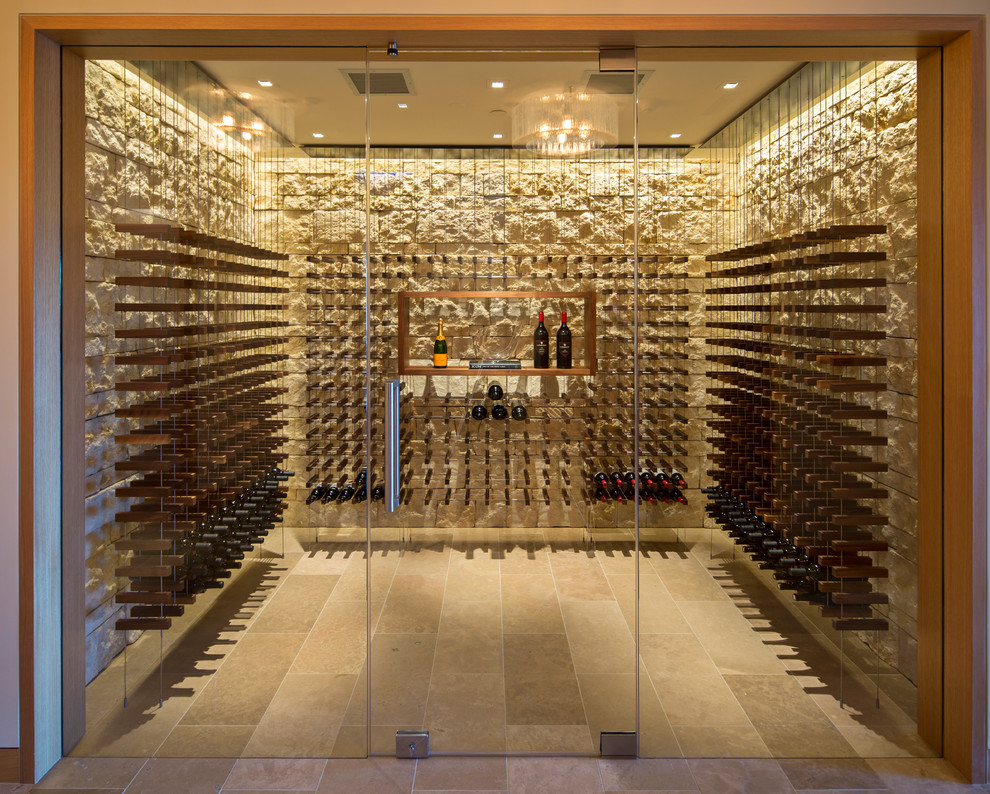 This is an example of a large contemporary wine cellar in San Francisco with travertine floors and display racks.