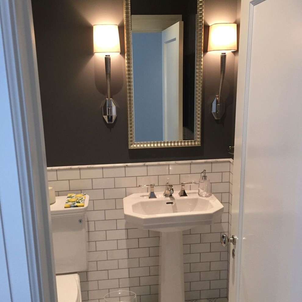 This is an example of a small transitional powder room in San Francisco with a one-piece toilet, white tile, subway tile, grey walls and a pedestal sink.