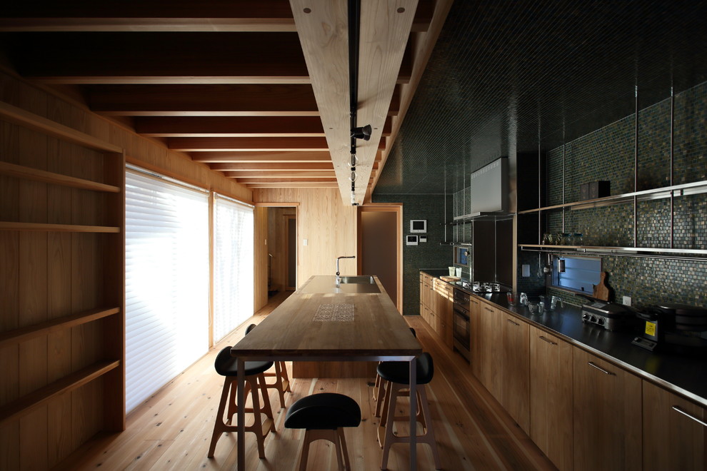 Photo of a mid-sized scandinavian single-wall separate kitchen in Nagoya with an integrated sink, beaded inset cabinets, dark wood cabinets, stainless steel benchtops, green splashback, mosaic tile splashback, stainless steel appliances, medium hardwood floors, with island, beige floor and brown benchtop.