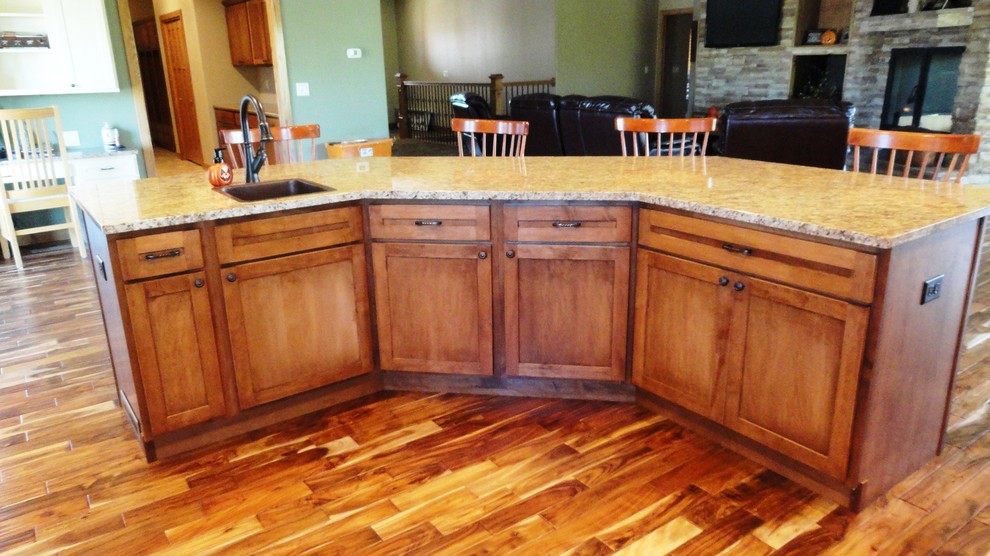 Example of a large l-shaped open concept kitchen design with a farmhouse sink, flat-panel cabinets, medium tone wood cabinets, granite countertops, stainless steel appliances, green walls and an island