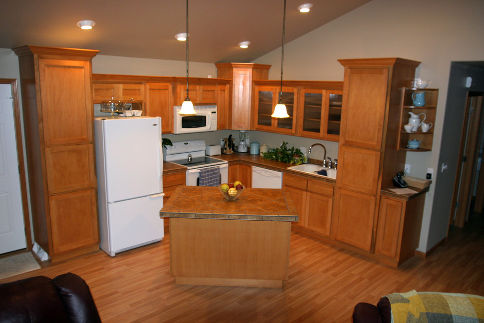 Inspiration for a small l-shaped open concept kitchen remodel with shaker cabinets, light wood cabinets, tile countertops, white appliances and an island
