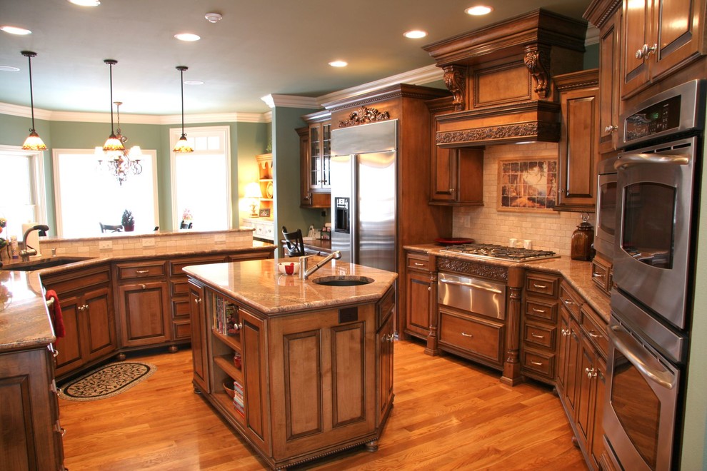 Large u-shaped medium tone wood floor eat-in kitchen photo with an undermount sink, raised-panel cabinets, white cabinets, granite countertops, beige backsplash, subway tile backsplash, stainless steel appliances and a peninsula