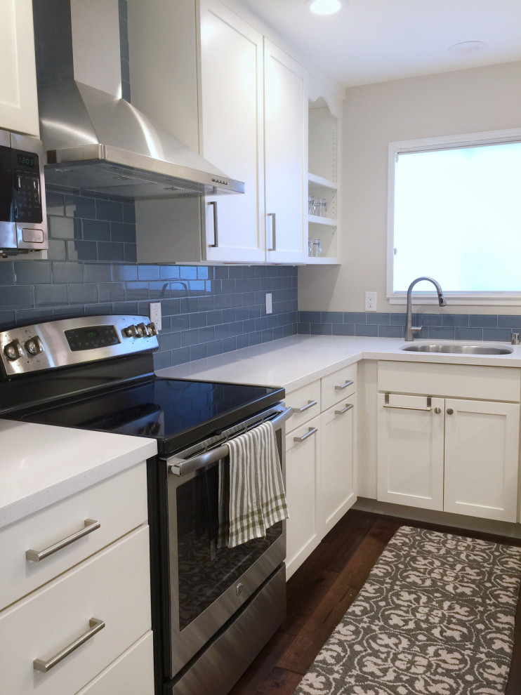 Inspiration for a small transitional u-shaped medium tone wood floor eat-in kitchen remodel with an undermount sink, shaker cabinets, white cabinets, quartzite countertops, blue backsplash, glass tile backsplash, stainless steel appliances and white countertops