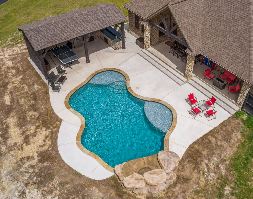 Inspiration for a mid-sized rustic backyard concrete and custom-shaped natural pool remodel
