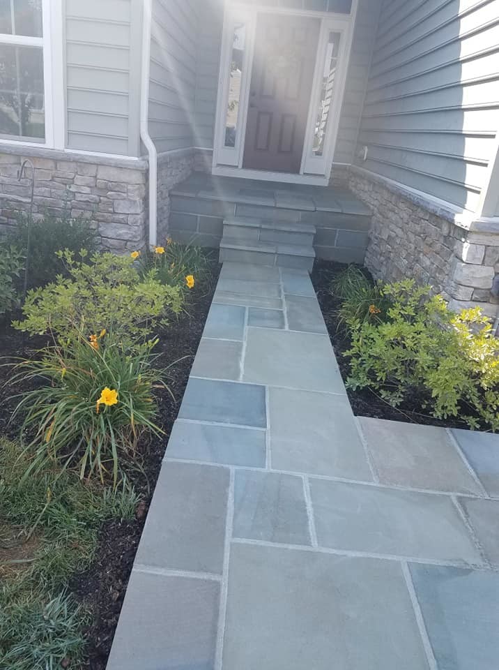 Small traditional front yard patio in Other with a vegetable garden and natural stone pavers.