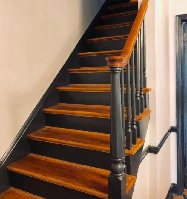 This is an example of a mid-sized transitional wood straight staircase in New York with painted wood risers and wood railing.